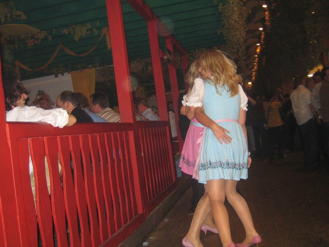 Två kvinnor i blå och rosa Dirndl-klänningar på en festival.